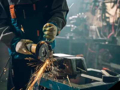 Person using angle grinder with sparks flying.