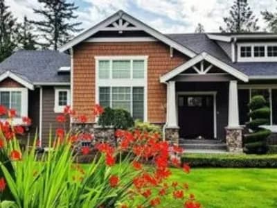 Charming house with red flowers and greenery.